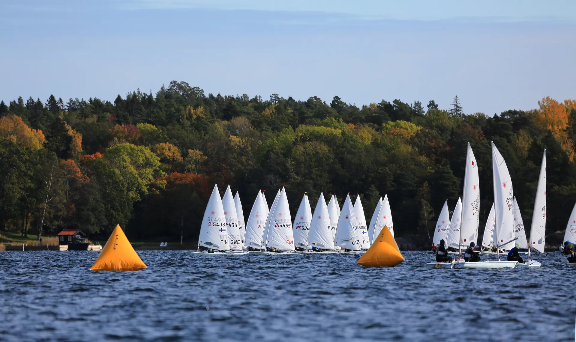 A fleet of dinghies racing between two orange marks